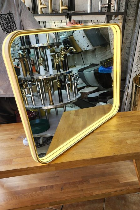 مرآة مضيئة بإطار ذهبي وحواف دائرية